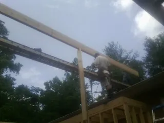 Carpenter setting a ridge beam over a new addition frame — Ice Dam Removal by Roofing Brothers in Cold Spring