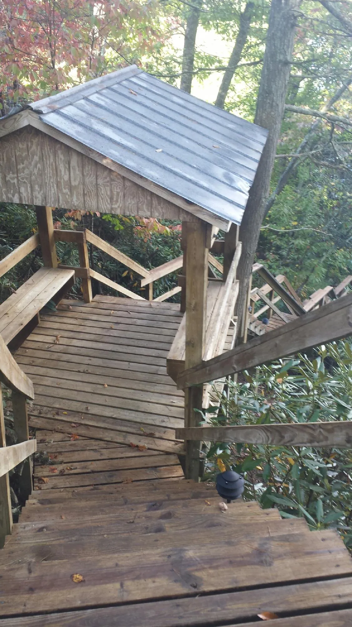 Metal roofed shelter over wooden steps on a wooded walkway — Skylight Repair & Installation work by our crew in Cold Spring